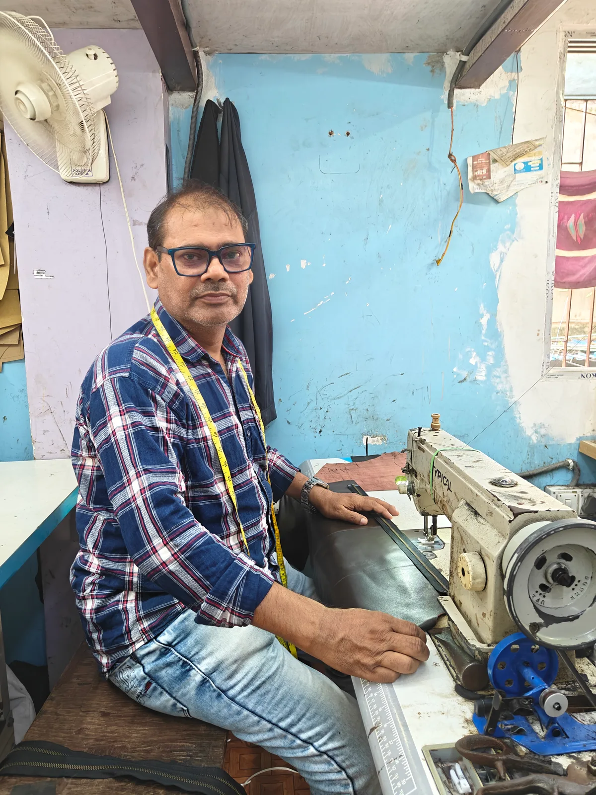Md Zahid Hossain, founder of Winston Hide, stitching leather at the workshop sewing machine